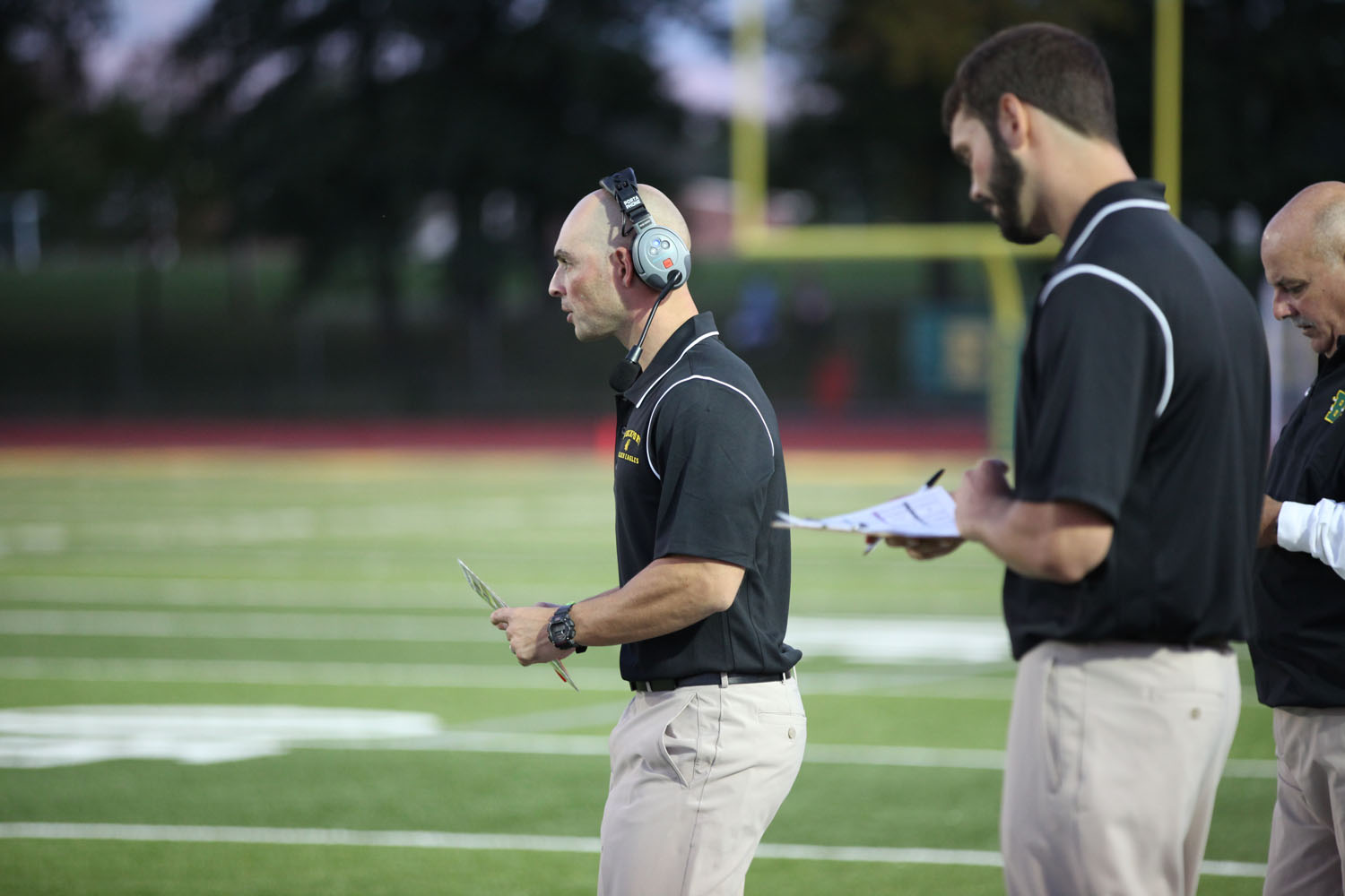 Coach Mangone checking with his team on the field