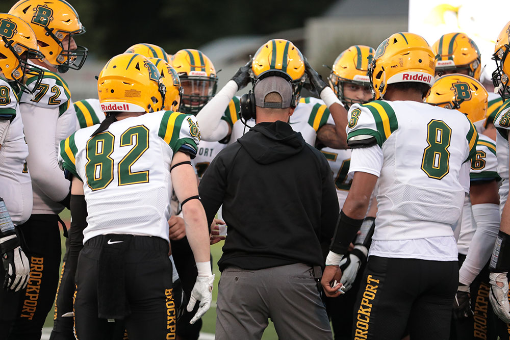 Coach going over the play with his squad