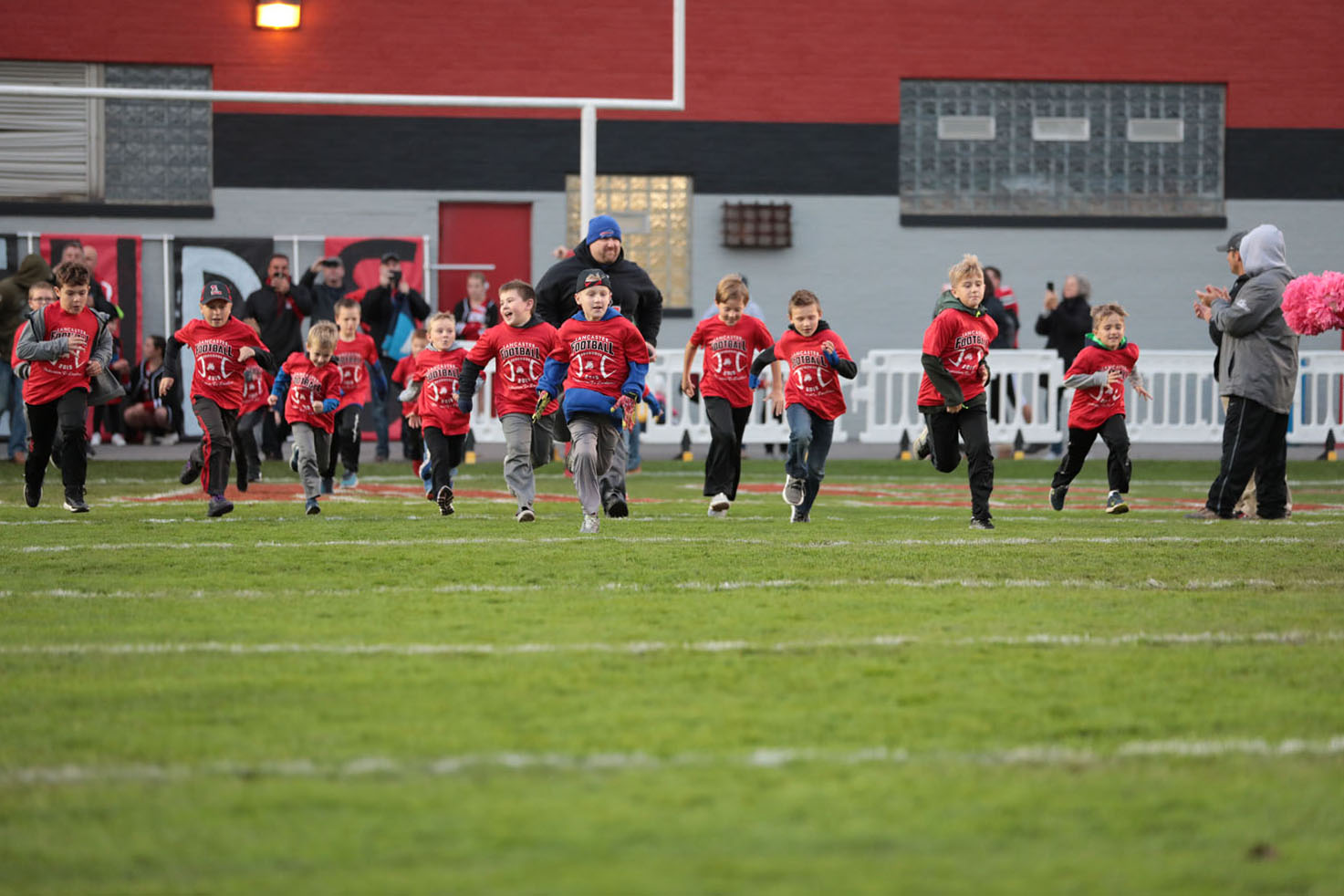 Junior Lancaster Football Players running onto the field