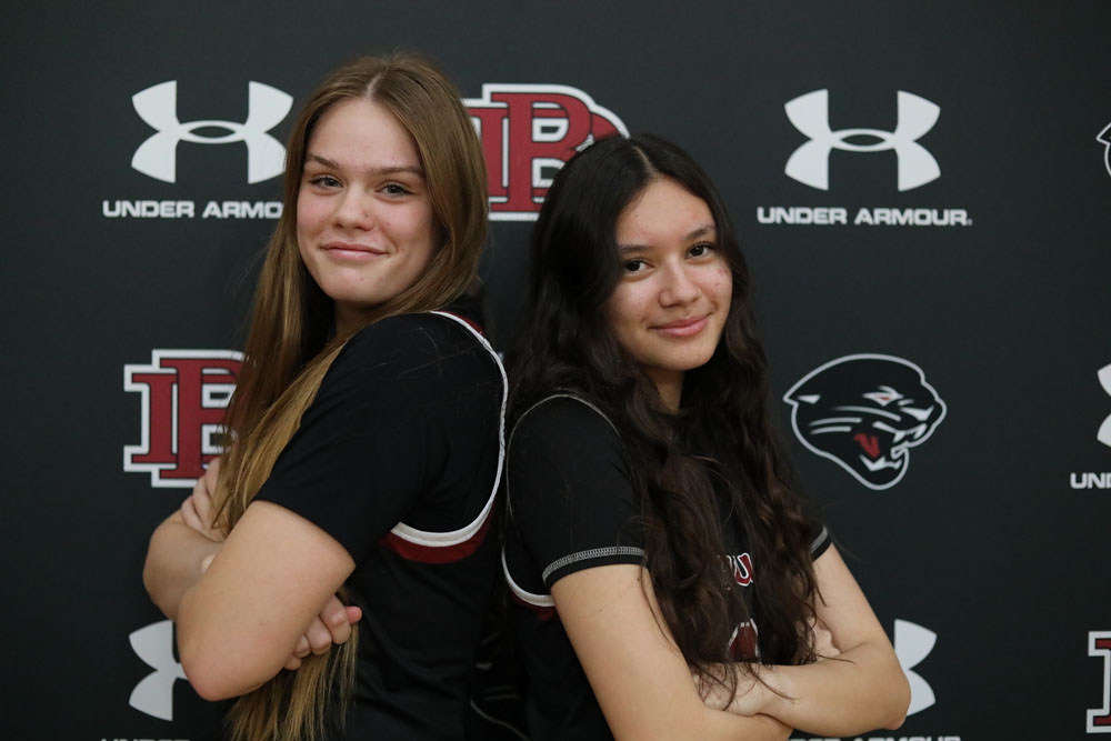 Ladies basketball players posing back to back