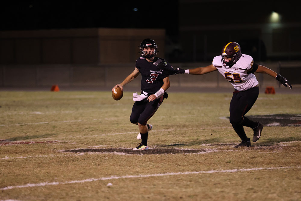 The Desert Ridge QB trying to get away as a defender holds his jersey