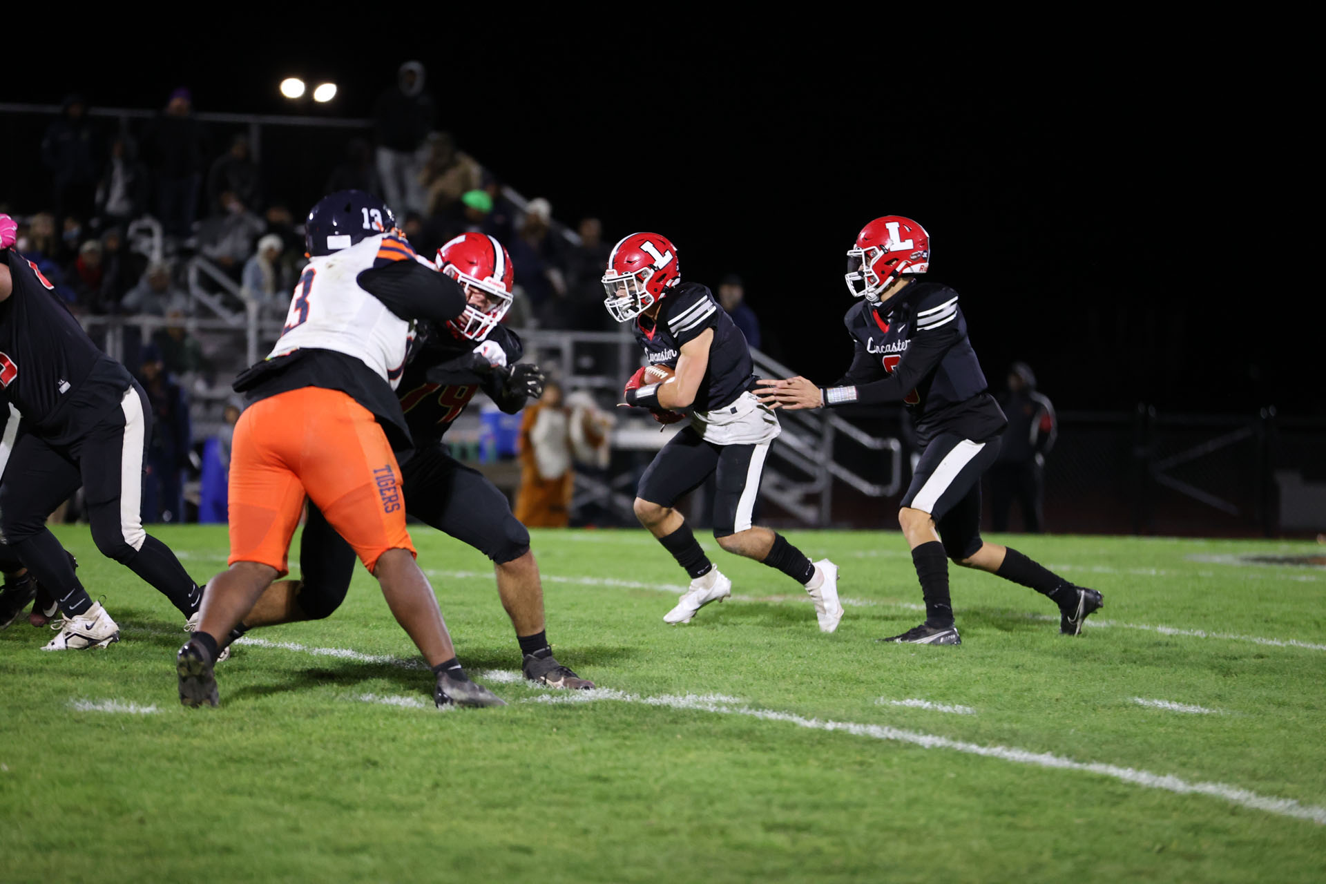 Quarterback for Lancaster hands off to the Running Back