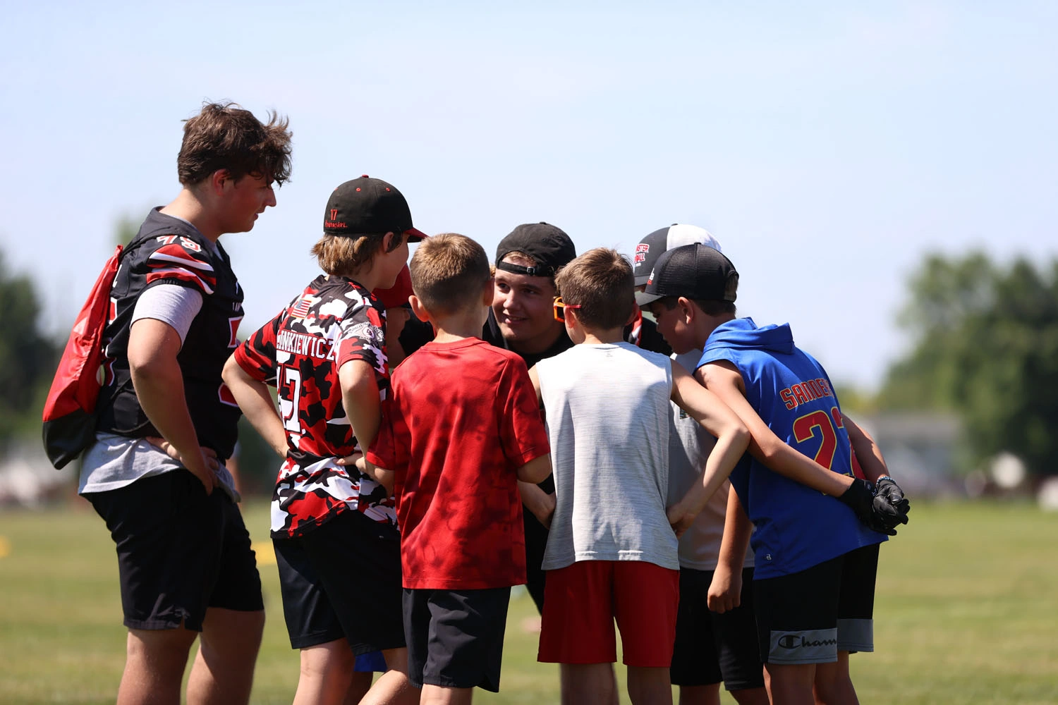 Campers in a huddle with coach